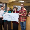 Counseling and Psychological Services Center staff hold up giant check for suicide prevention program
